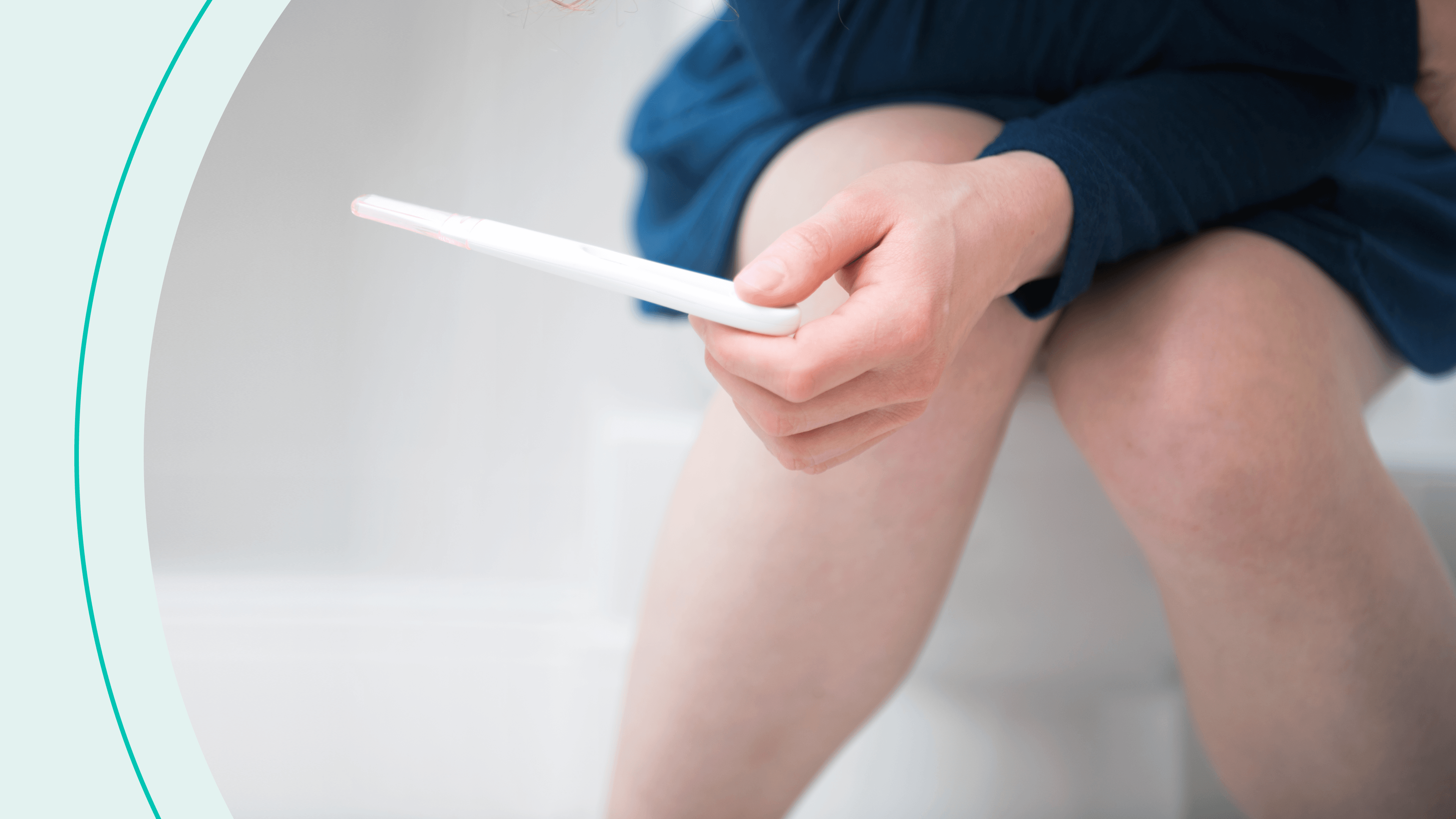 A woman sitting on toilet holding a pregnancy test