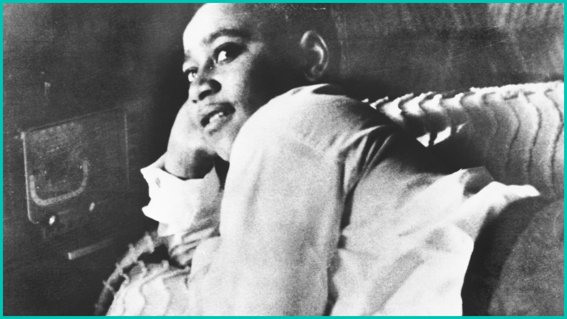 Emmett Till is shown lying on his bed.