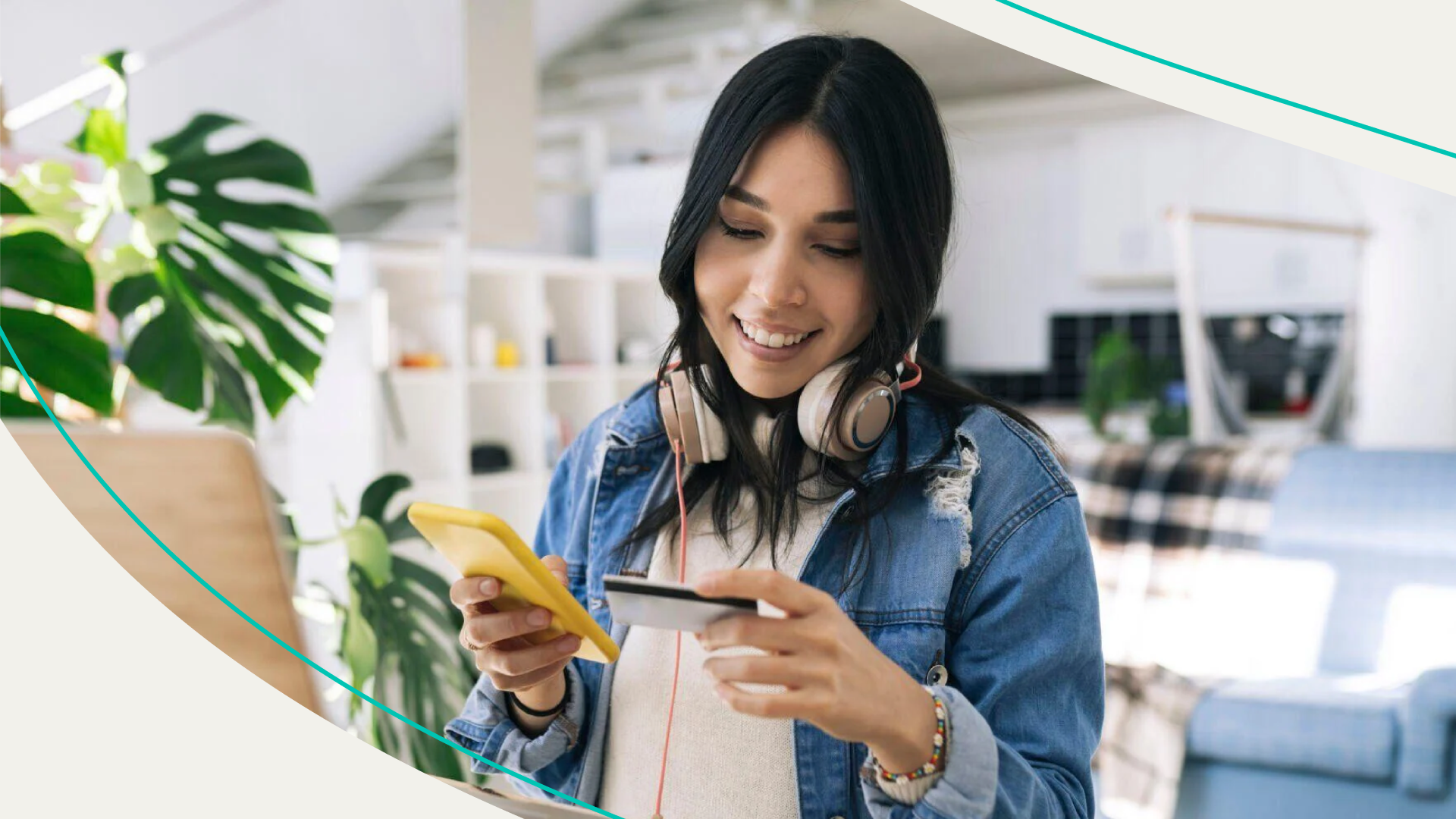 woman with laptop looking at her phone and credit card