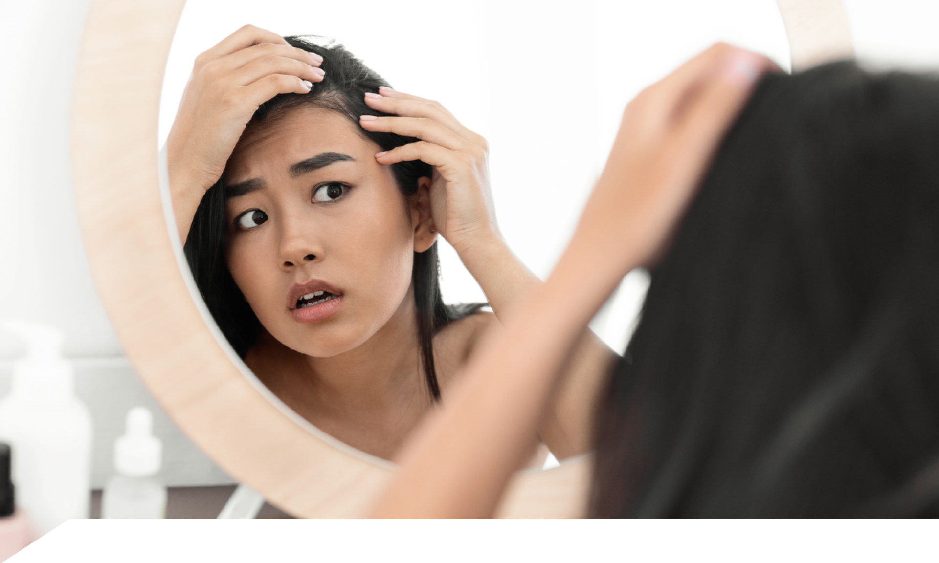 Woman looking at scalp in mirror