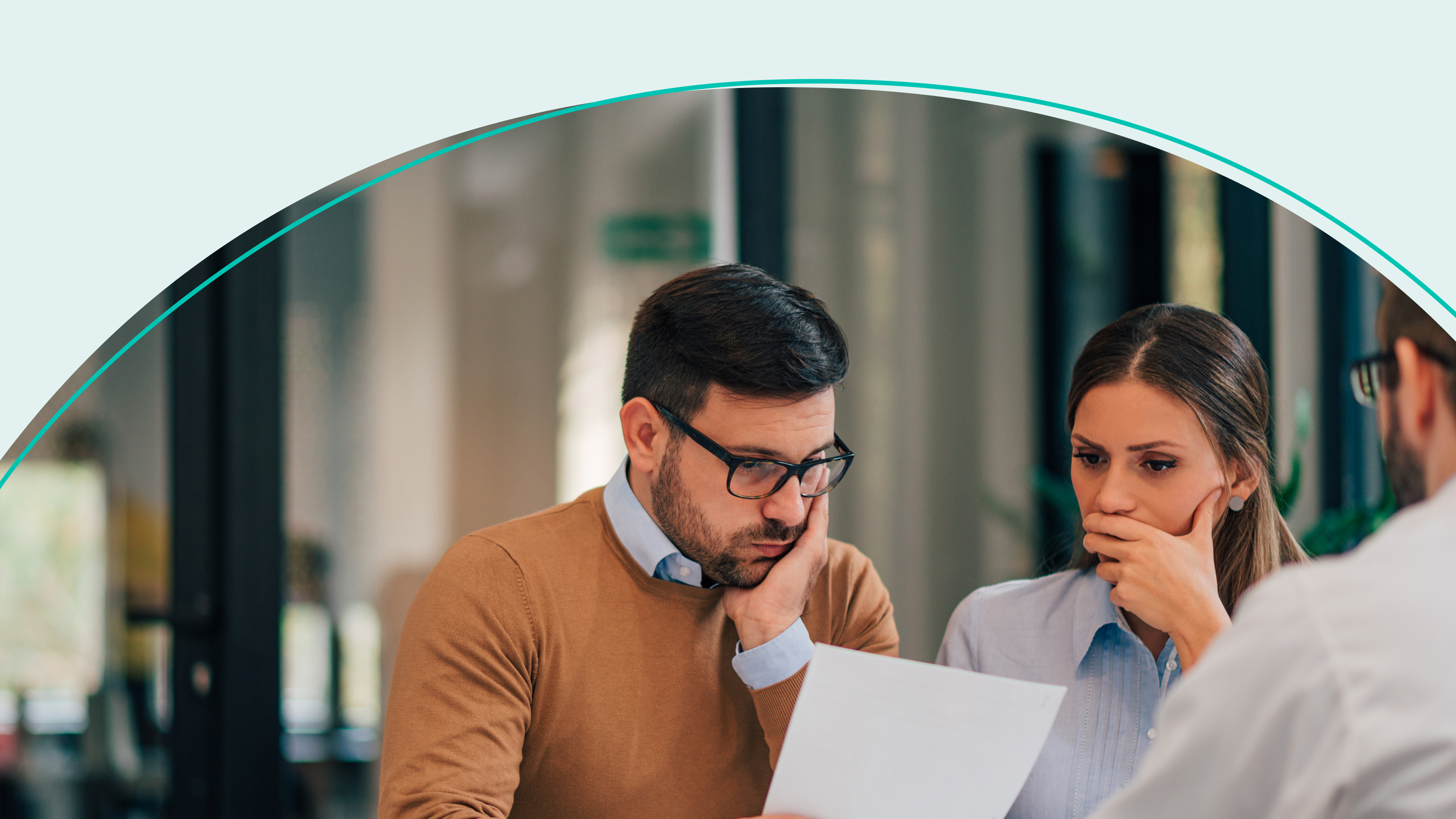 couple looking at paper with concerned expressions