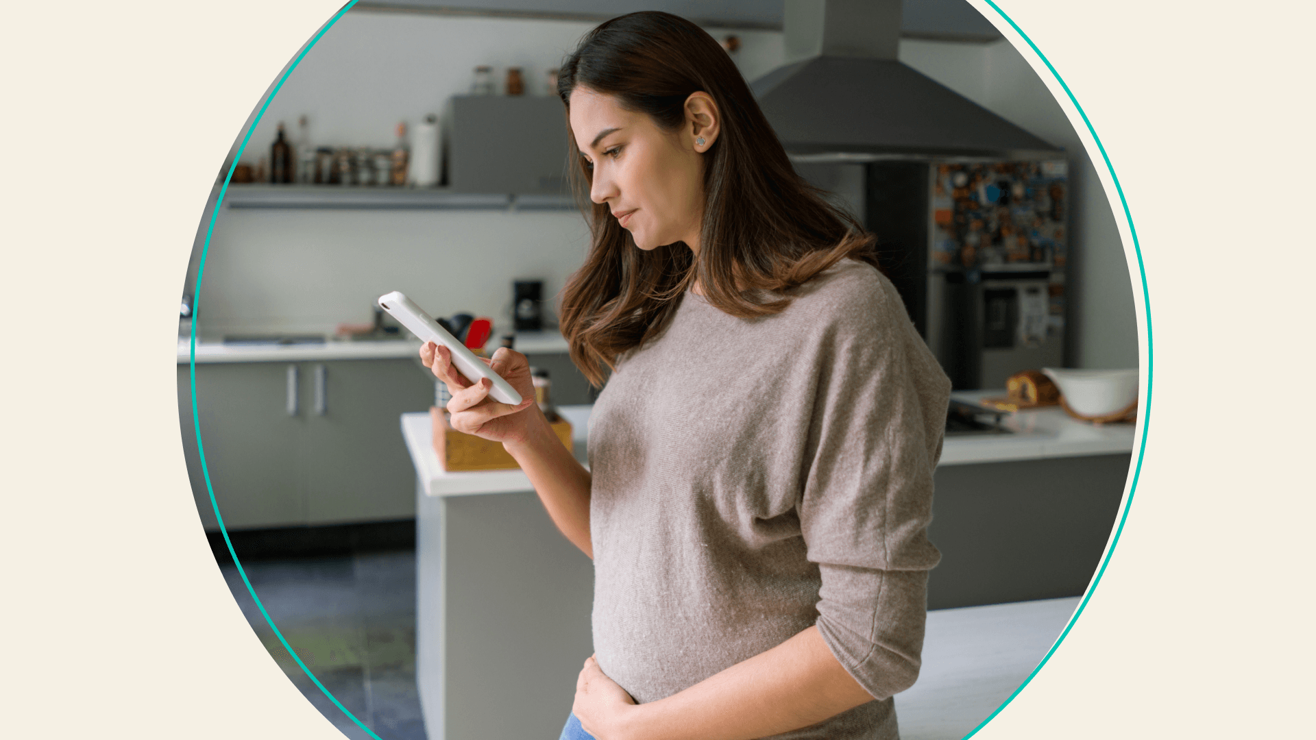 A woman holding her stomach and looking at her phone