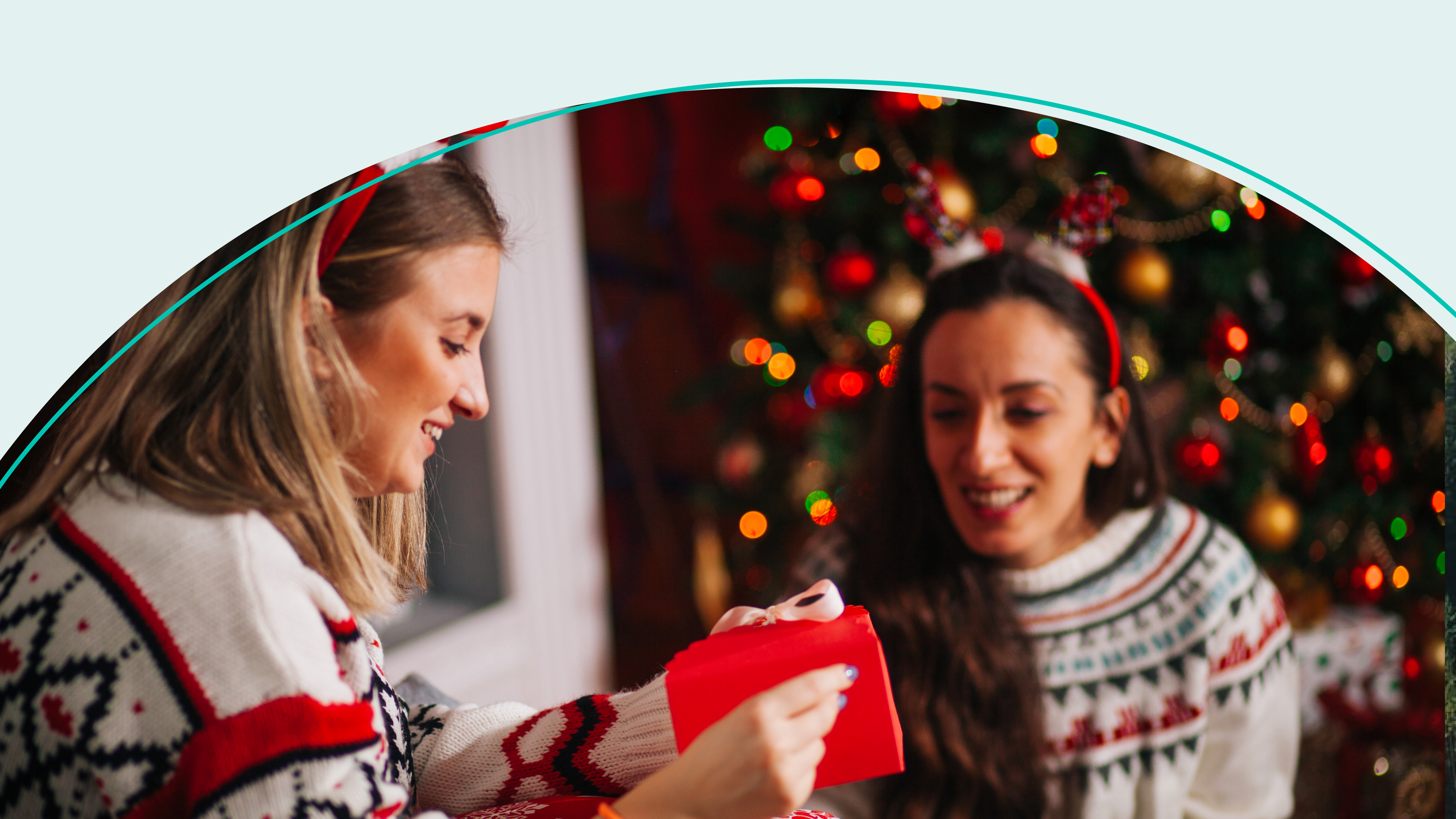 Women exchange gifts in front of a festive background 