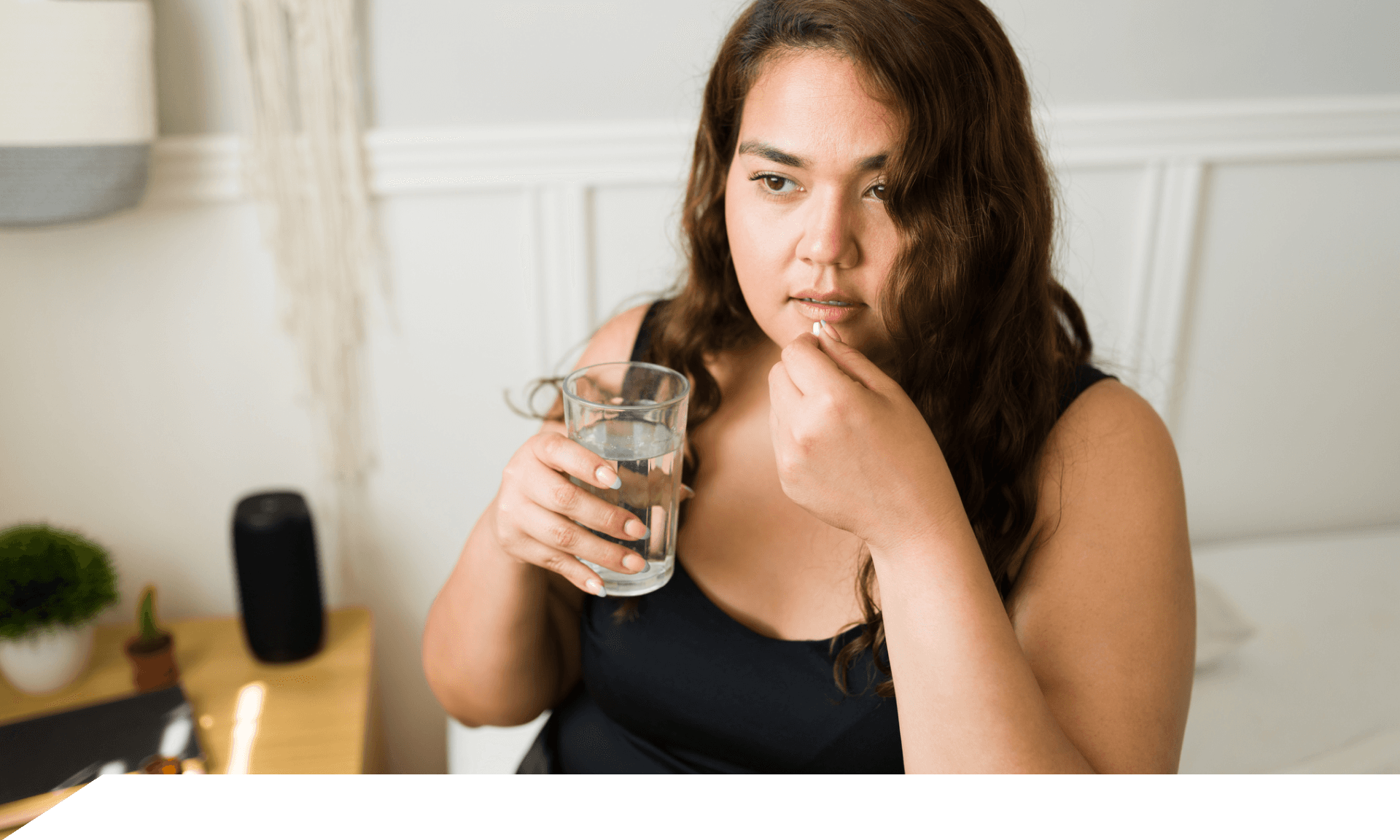 Woman holding pill and glass of water